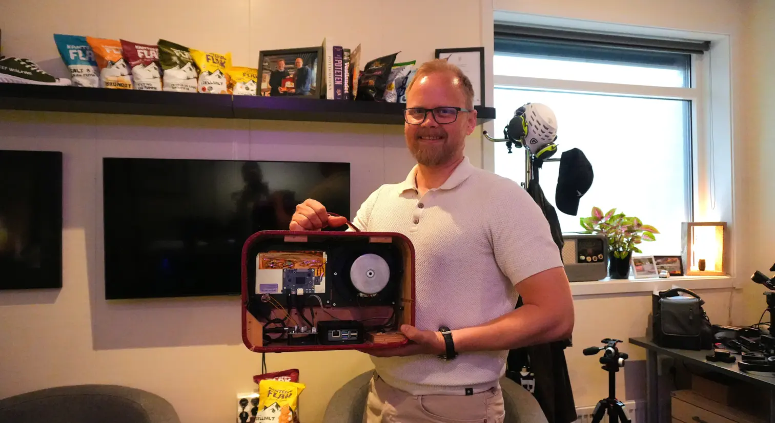 Mann holder gammel radio for å vise innmaten